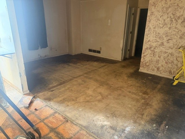 Empty room with concrete floor and exposed walls during renovation